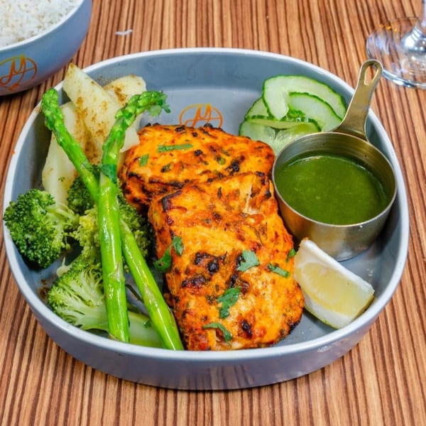 Mausam Indian Flavors' grilled salmon with asparagus, broccoli, potatoes, and green chutney.